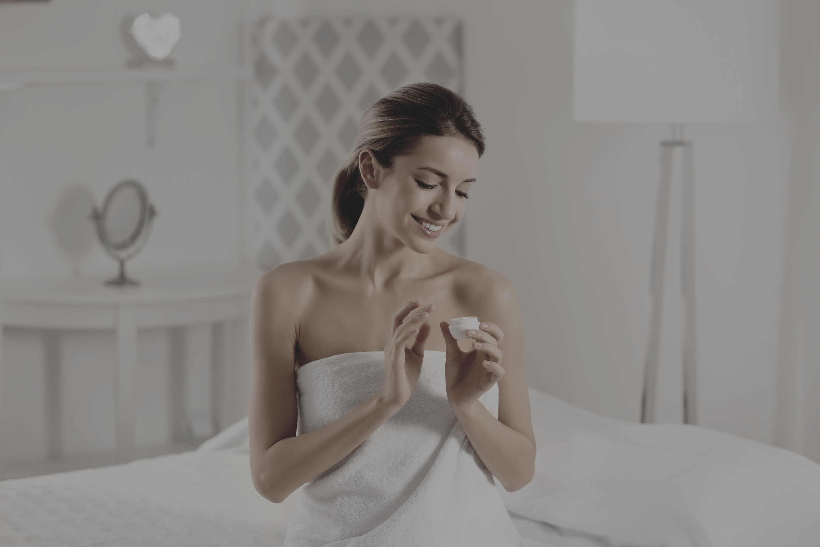 Woman Wearing a Towel Holding a Jar on the Bed